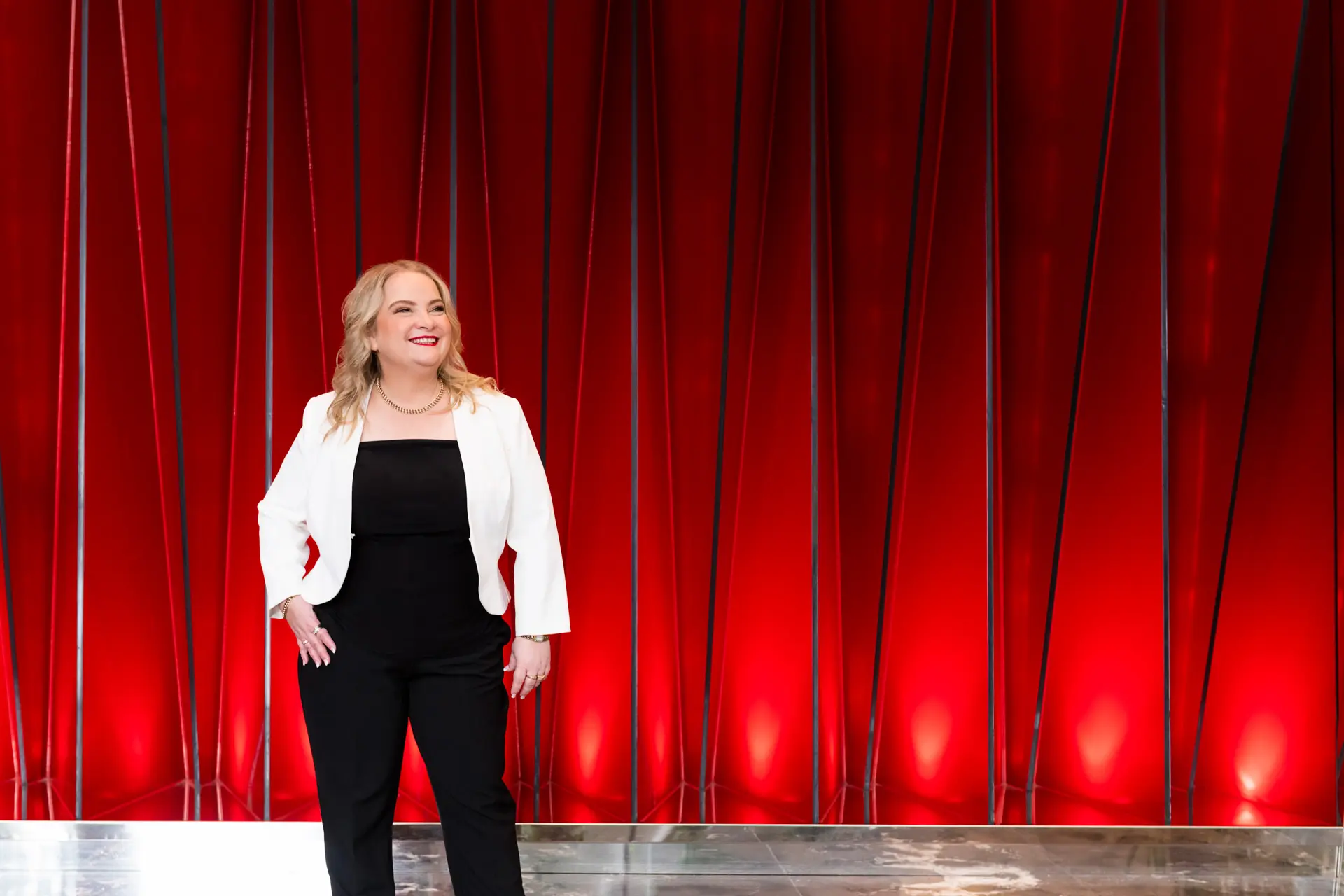 Juanita Wheeler standing in front of a striking red architectural wall