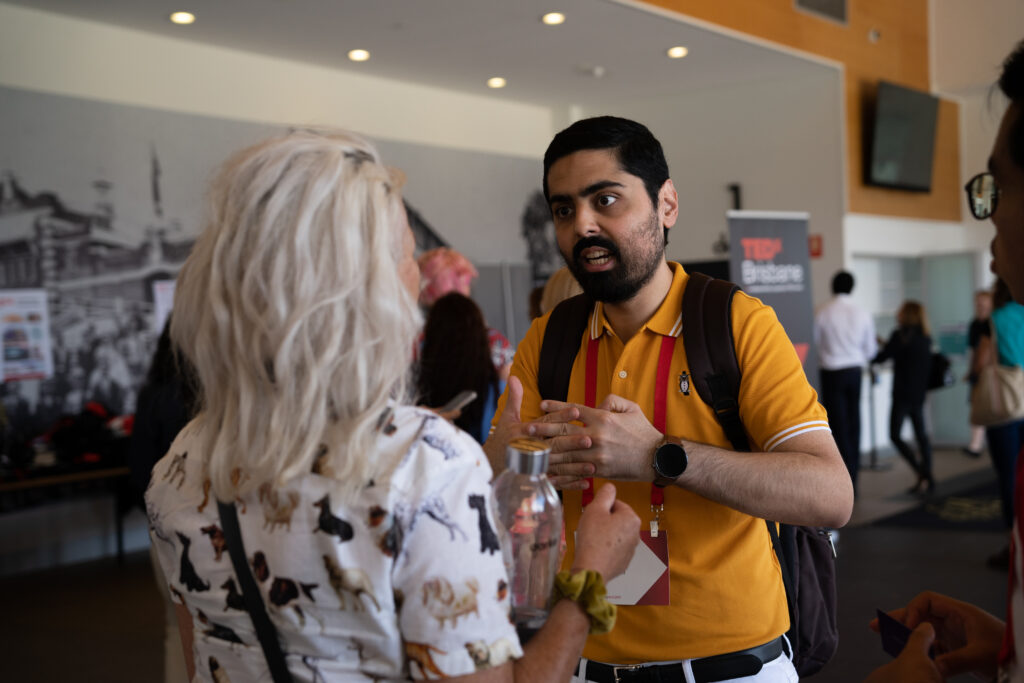 Danish Kazmi speaking to a blonde audience member at the Speaker Spot